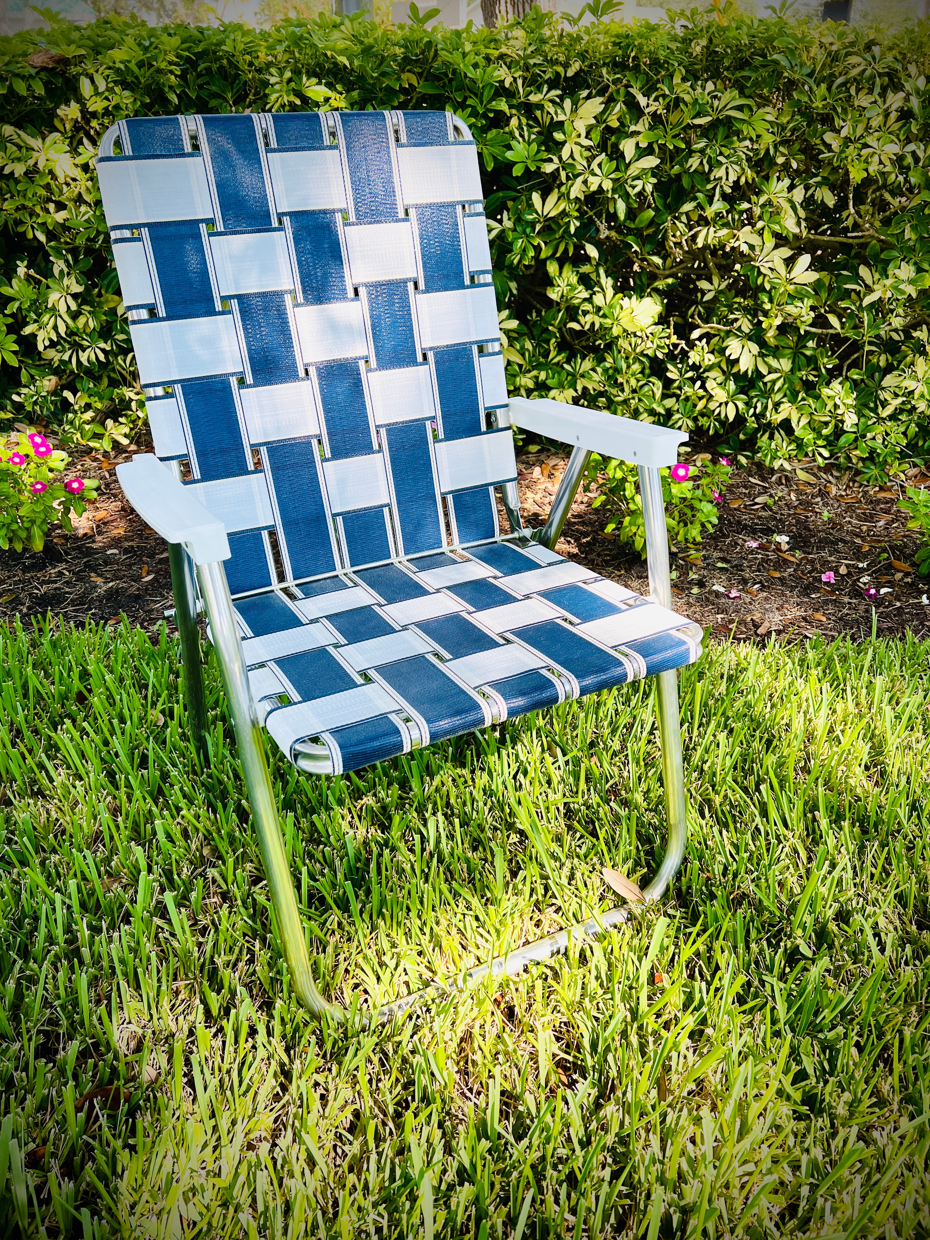 St. Augustine Classic Chair Lawn Chair USA Aluminum Webbing Chair Sitting Outside in Grass flowers